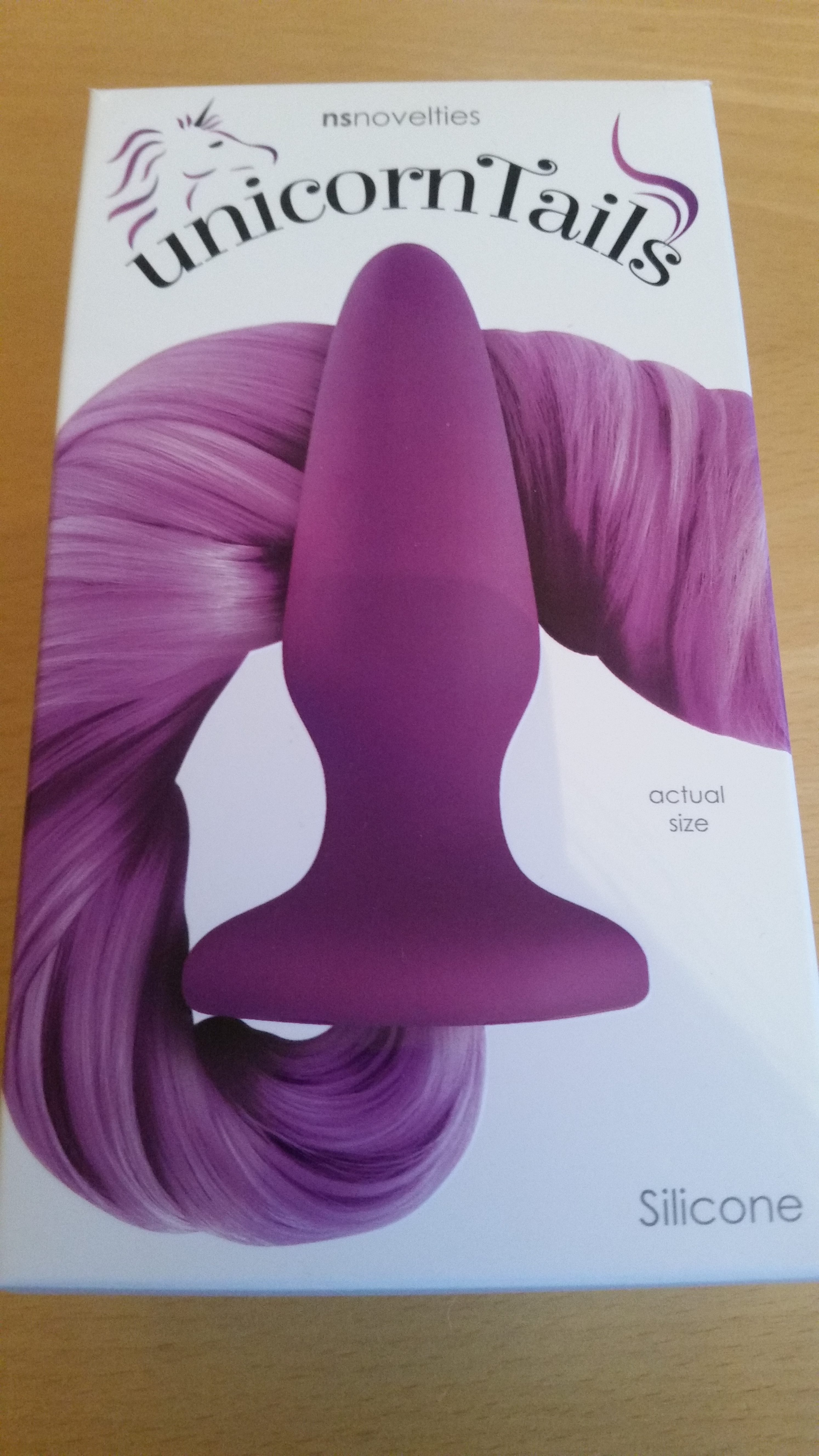 The NS Novelties purple unicorn tail butt plug, boxed. For a product review.