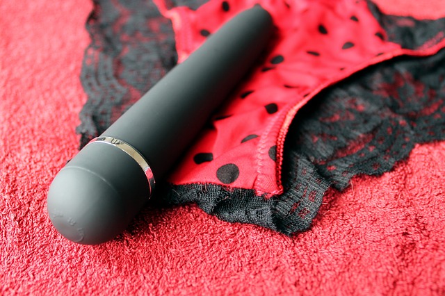 A pair of red panties with black spots and a black vibrator lying on a red carpet. For a post about the 30 Day Orgasm Fun challenge.