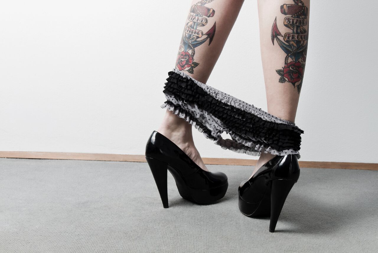 A white woman's tattooed lower legs, wearing black high heels and black knickers around her ankles. By Hot Octopuss. For a post on antidepressants and sex.