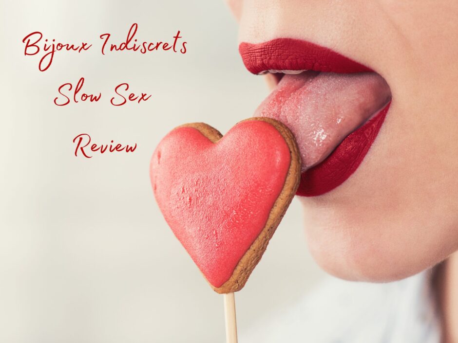 A woman's mouth seductively licking a heart-shaped lollipop. Text reads: Bijoux Indiscrets Slow Sex Review