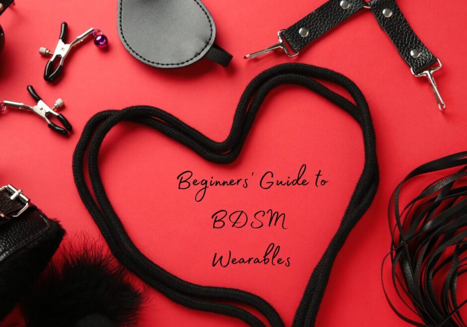 Several BDSM items including leather straps, nipple clamps, and a blindfold on a red background. A length of black rope forms a heart. Text in the middle of the heart reads: A Beginners' Guide to BDSM wearables