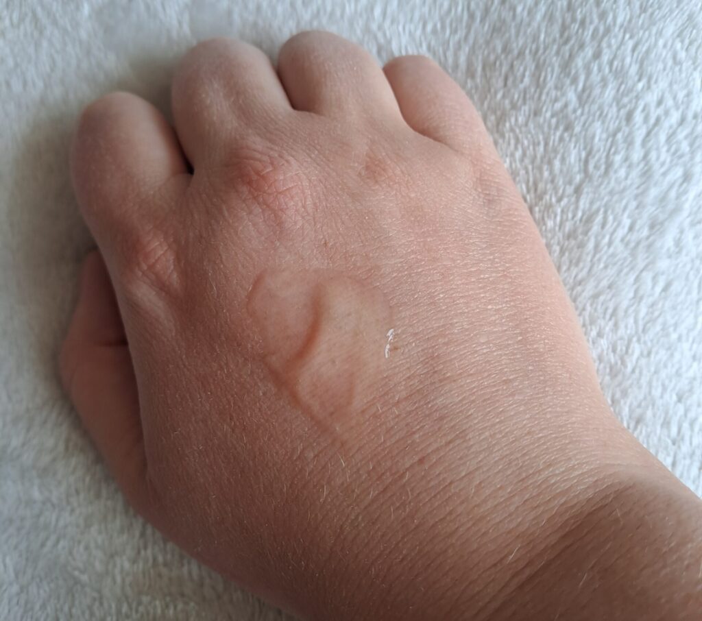 A woman's hand with a blob of clear lube on the back