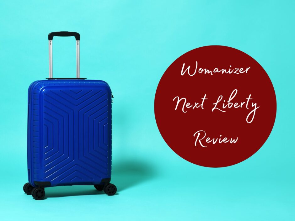 Header image with a blue wheely suitcase. Text reads: Womanizer Next Liberty Review